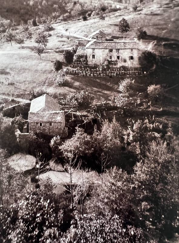 Photo ancienne du Moulin du Pistou : la ferme et le moulin vus d'en haut, entourés d'arbres